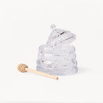 Gewurzhaus glass beehive-shaped honey jar with a matching lid and a small wooden honey dipper.
